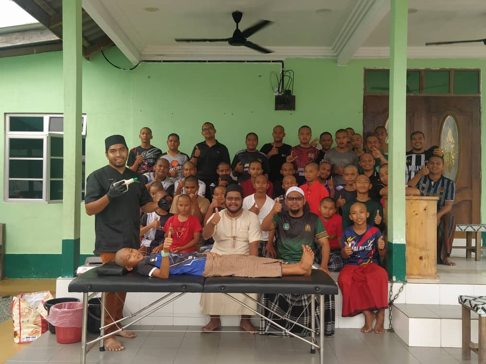 Foto berkumpulan bersama pengamal di sisi katil rawatan